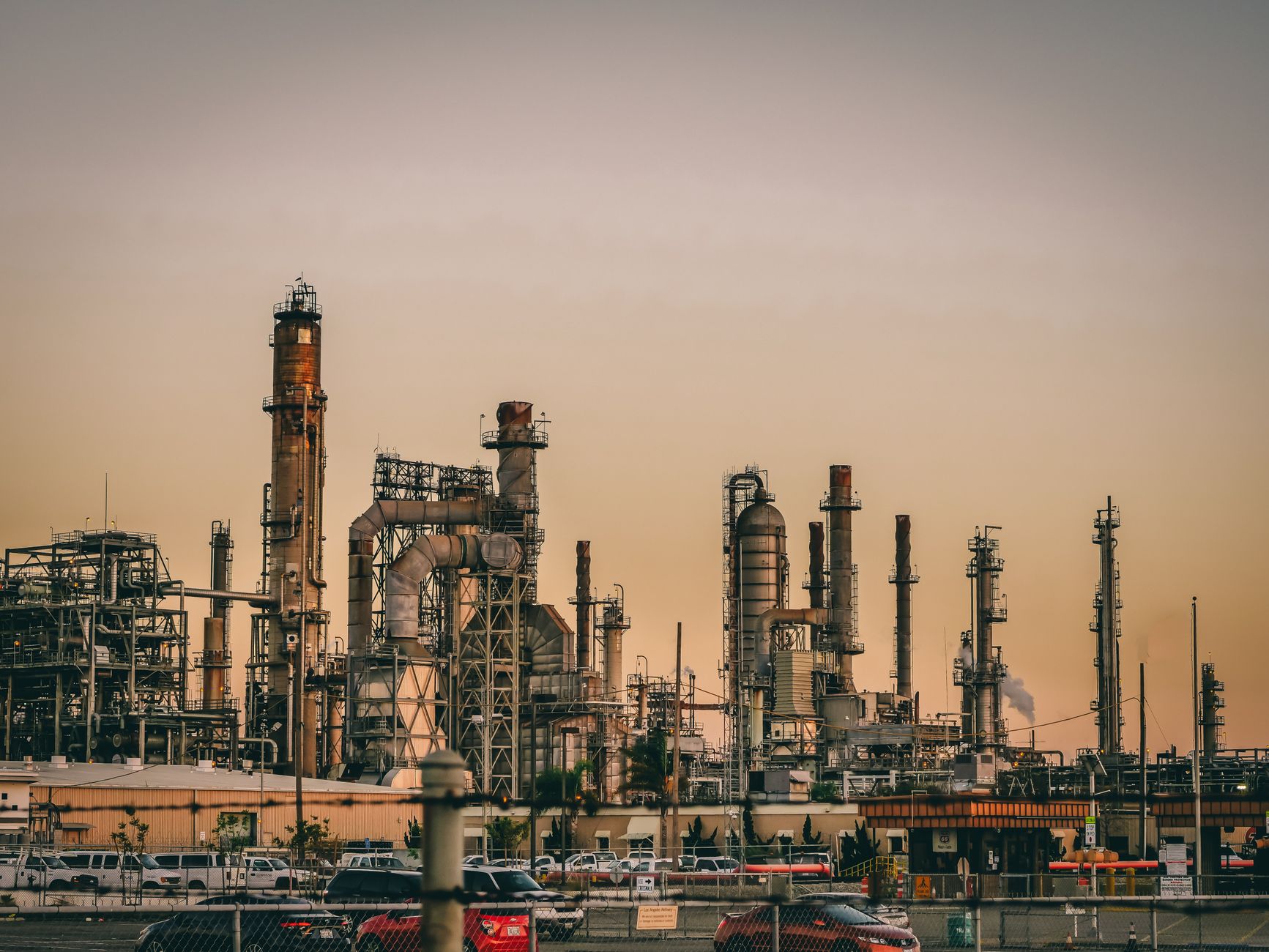A large industrial power plant silhouetted against the warm hues of a sunset.