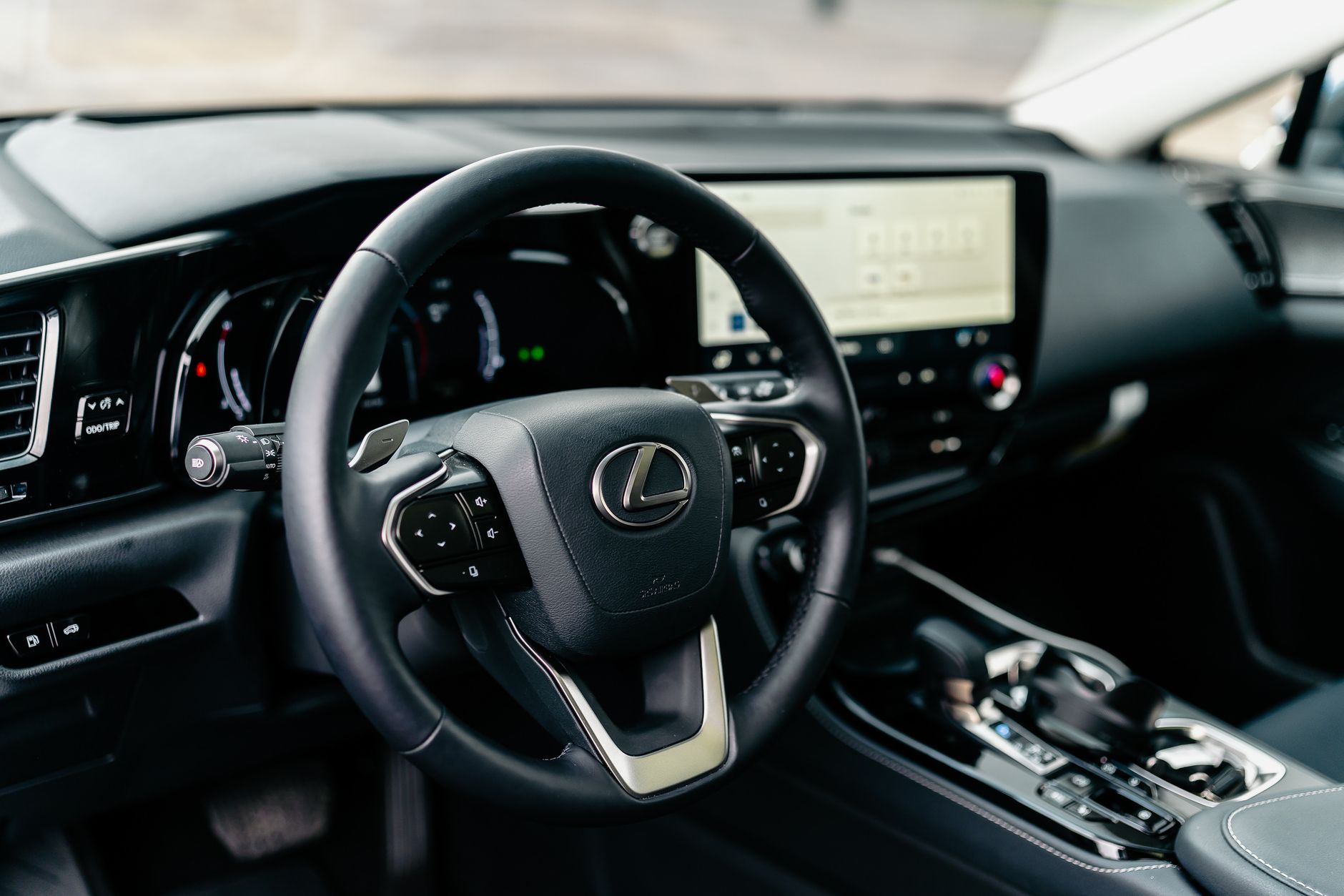 Close-up of a Lexus car interior showcasing the steering wheel and modern dashboard.