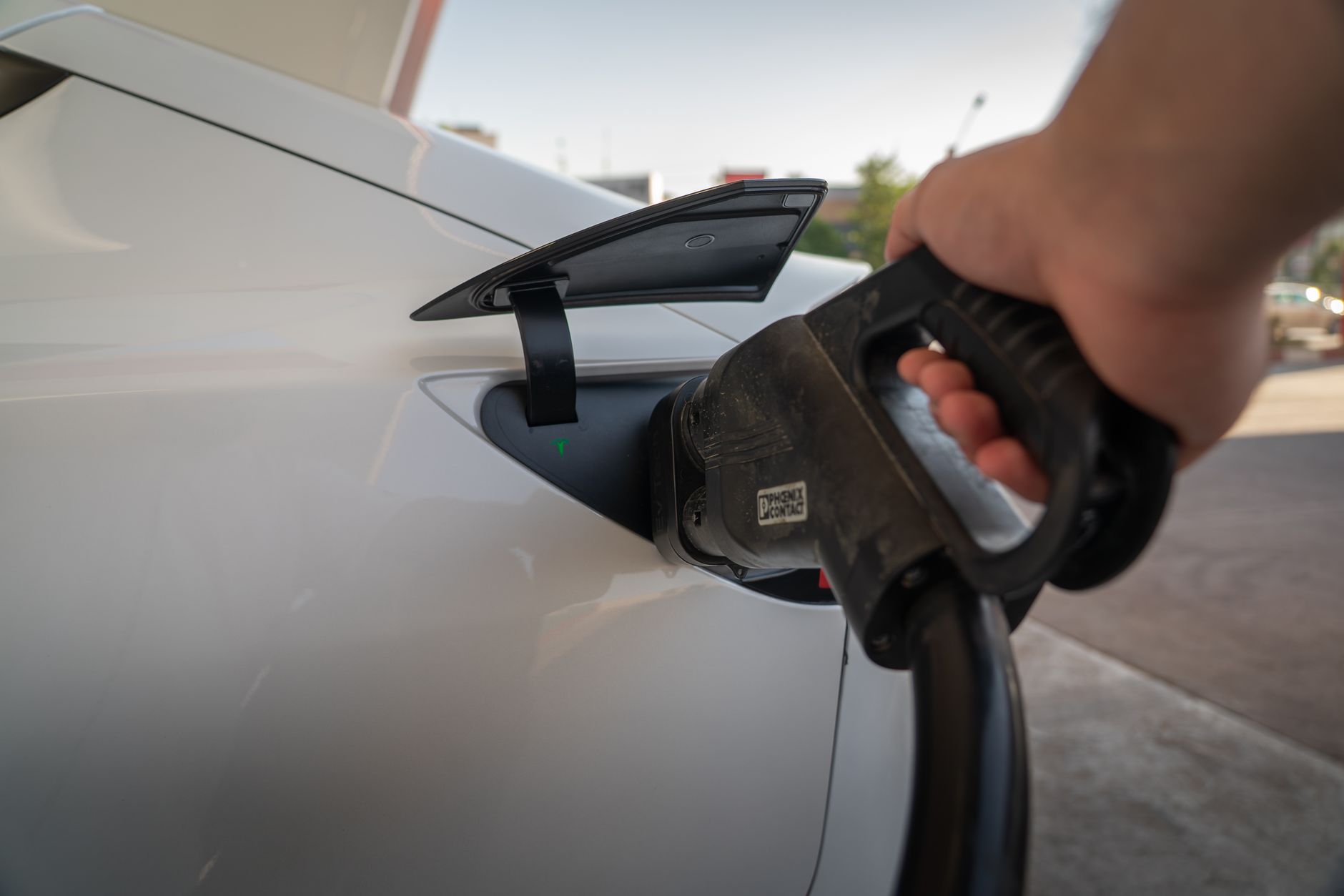 Close-up of electric car being charged, highlighting eco-friendly transportation.