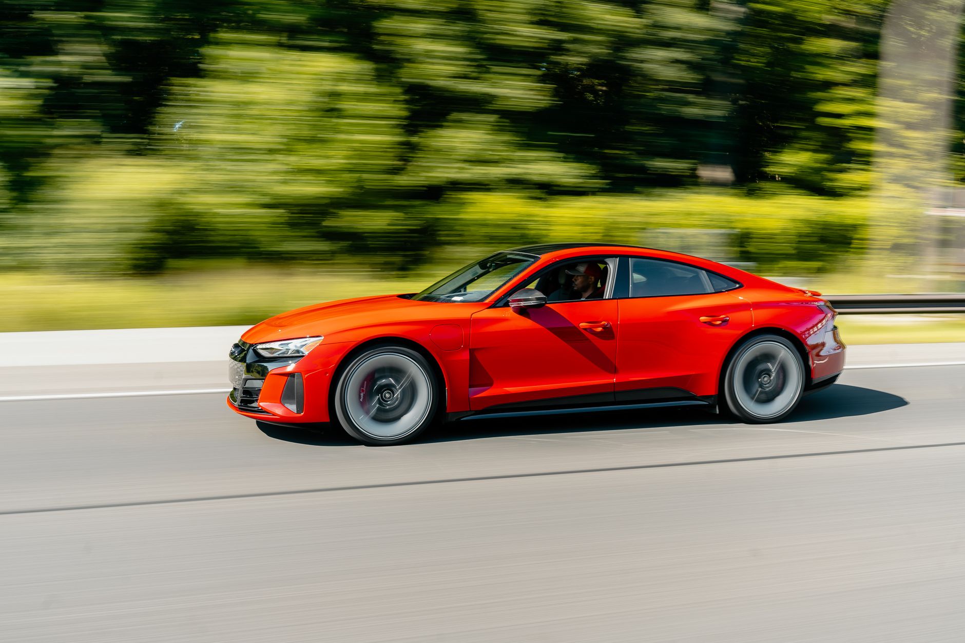 A sleek red electric car speeding on a highway near Silver Spring, MD, showcasing clean transportation.