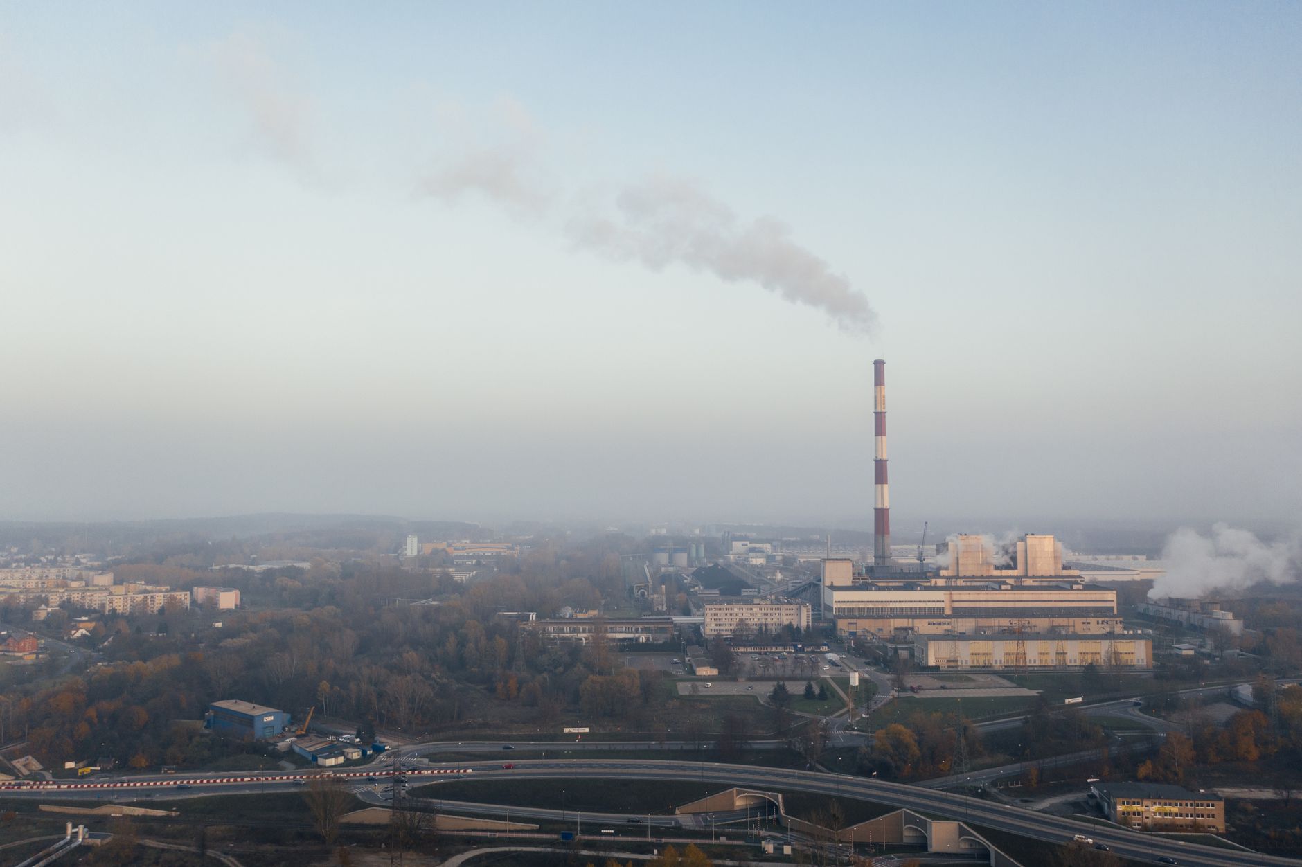 Aerial shot of a power plant emitting smoke, highlighting urban air pollution and industrial impact.