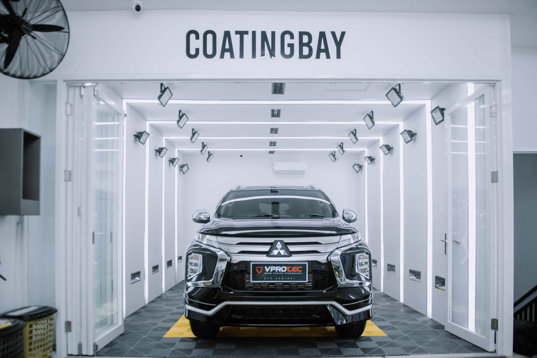 A sleek Mitsubishi SUV inside a modern automotive coating facility.