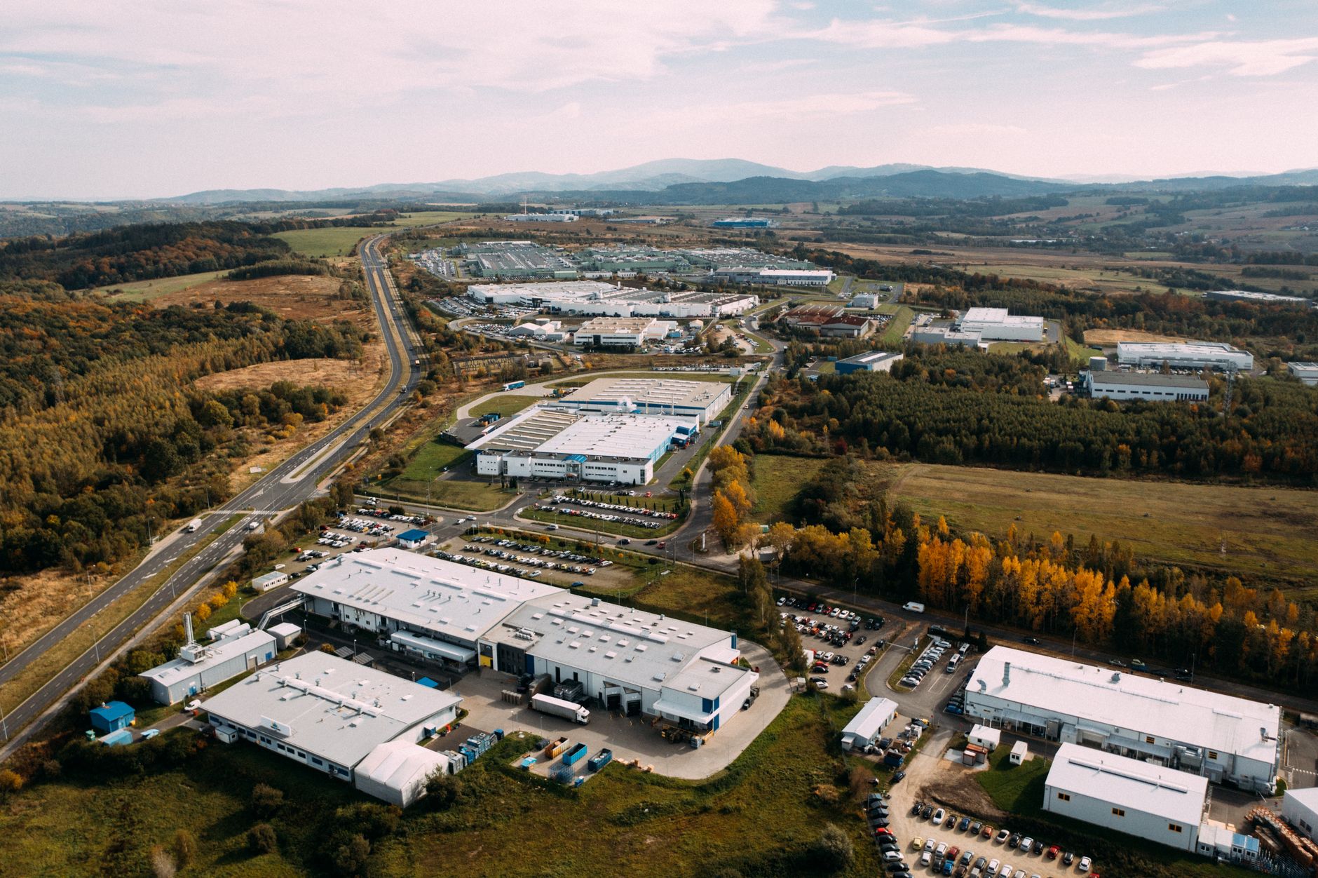 Aerial photograph of an expansive industrial complex surrounded by lush countryside and winding roads.
