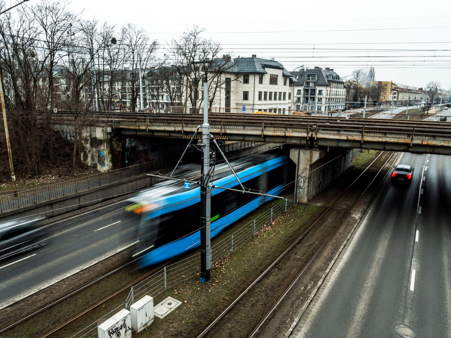 Dynamic urban scene in Wrocław with tram and cars on a busy street.