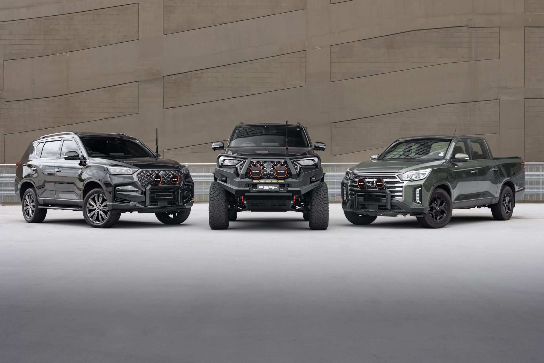 Three SUVs and trucks showcasing modern design in an urban environment.