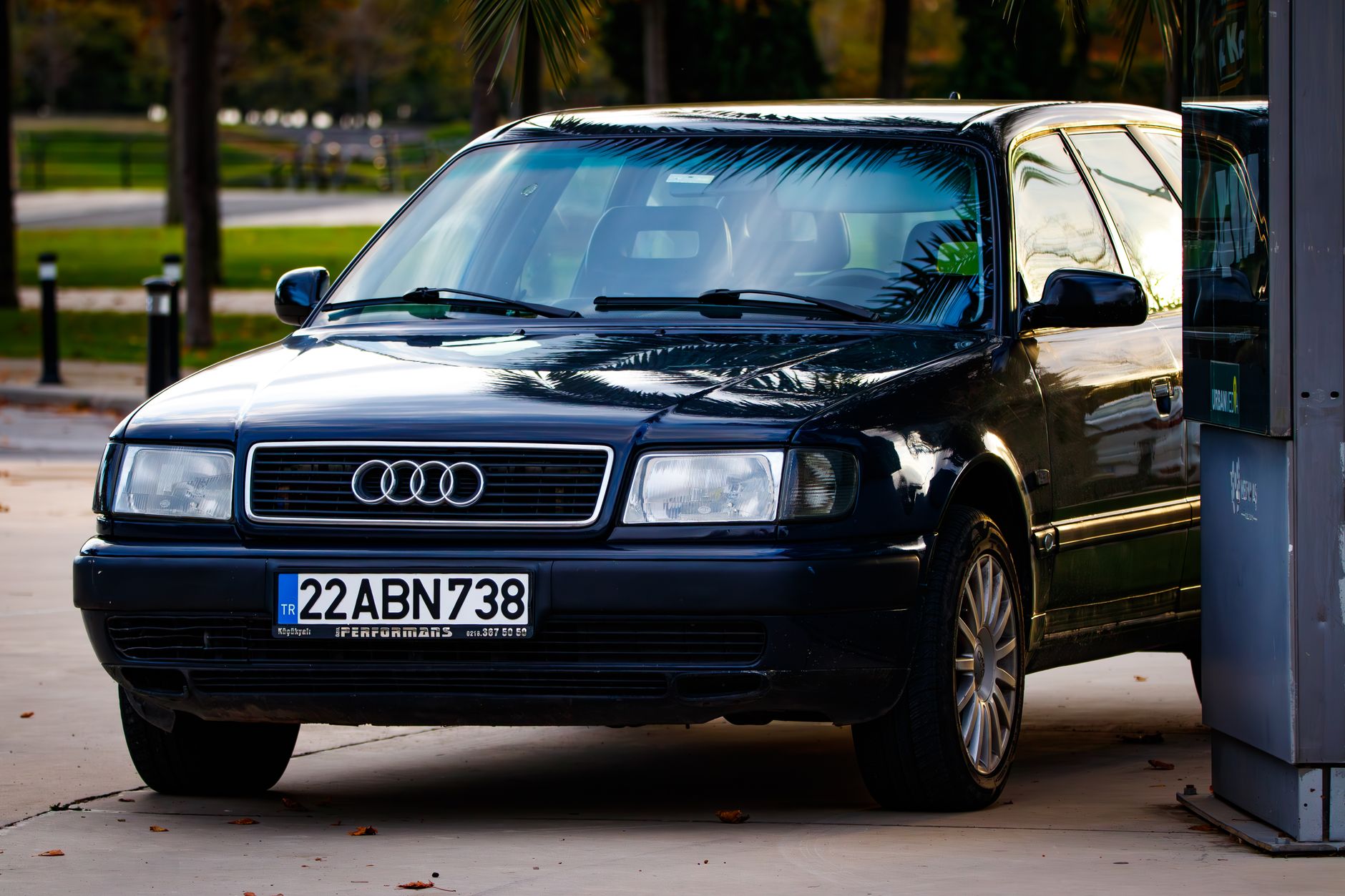 A sleek black Audi parked on an urban street during the day, reflecting the city environment.